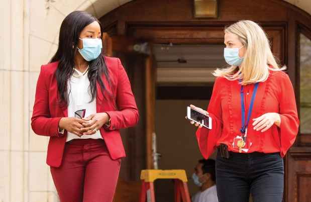 Two women walk outside brick building