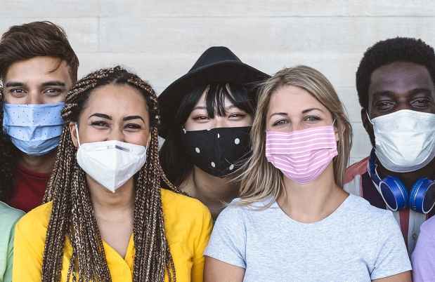 diverse group of young adults in masks against wall