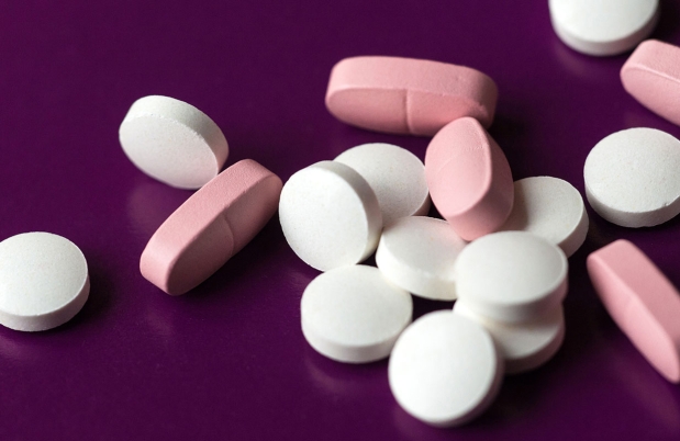 white and pink pills on purple background