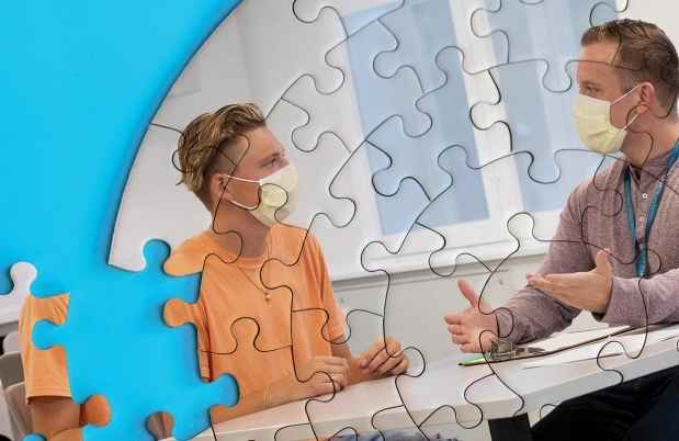 Puzzle pieces make up image of teen patient talking to clinician