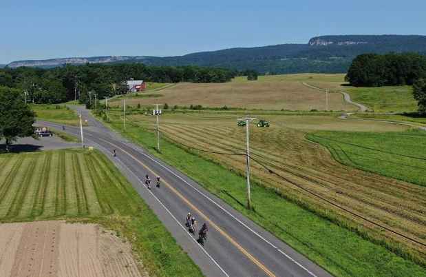 Bike riders on road in front of landscape