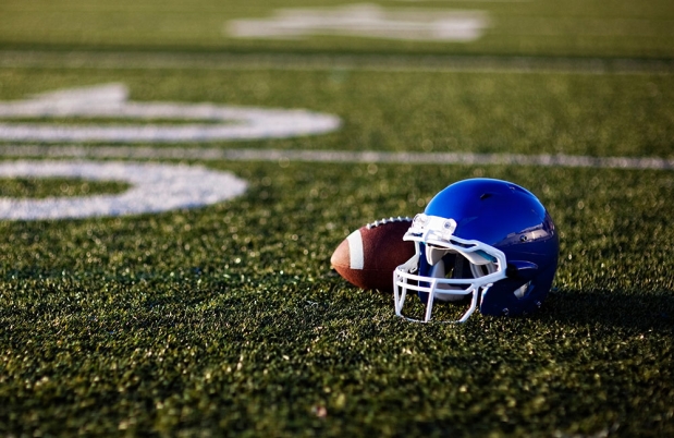 Blue helmet and football on football field