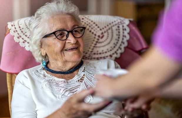 Older woman is given tea cup