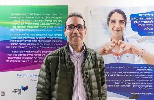 A man stands in front of a Deconstructing Stigma display