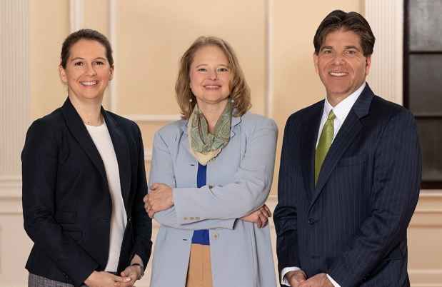 Three people standing and smiling at the camera
