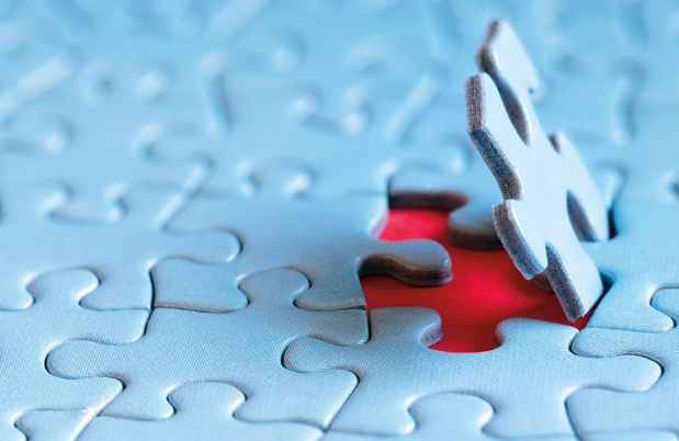 Puzzle piece fitting into place in a larger puzzle