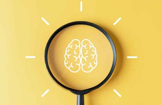 A magnifying glass over a minimalist illustration of a brain on a yellow background