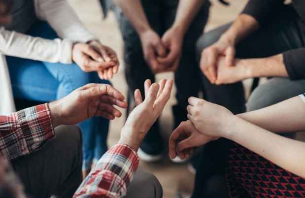 Hands of people in a circle during a group therapy