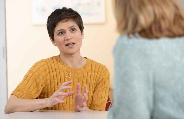 Woman in sweater talking to another woman