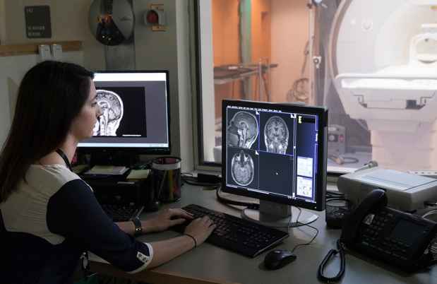 Woman looking at computer screen of brain scans