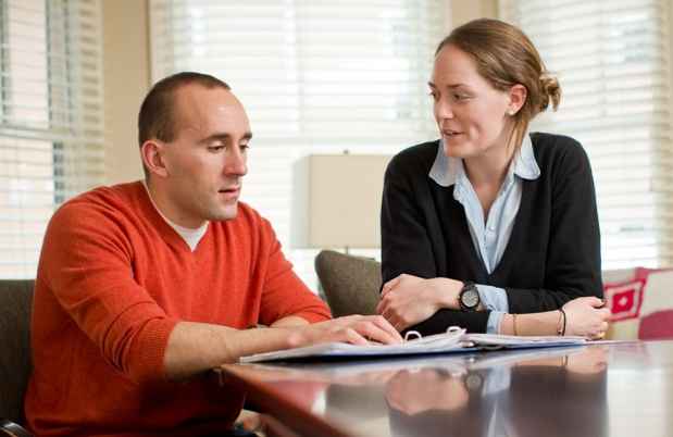 2 people sit at table talking