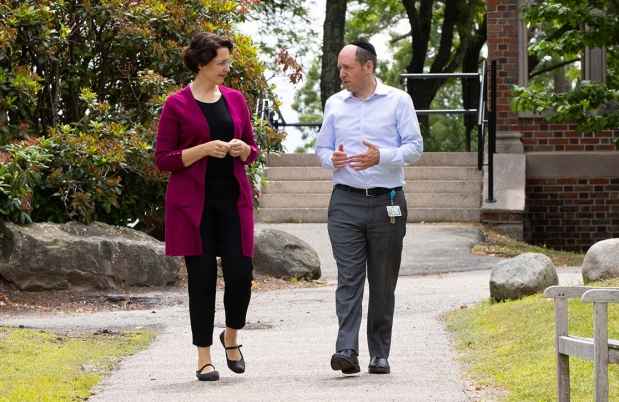 Two people walking and talking on a path outside