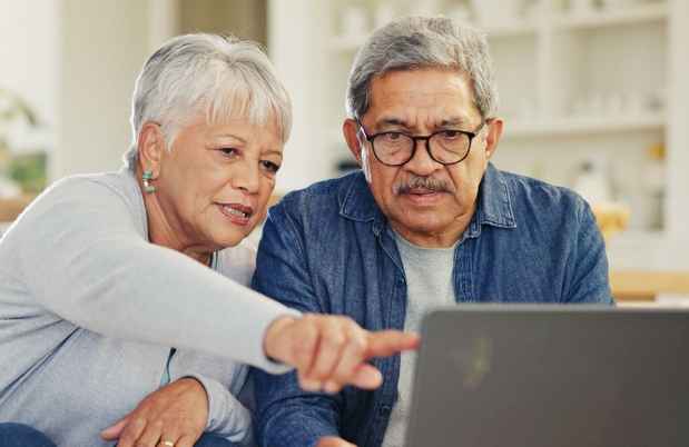 Senior couple at desk with laptop