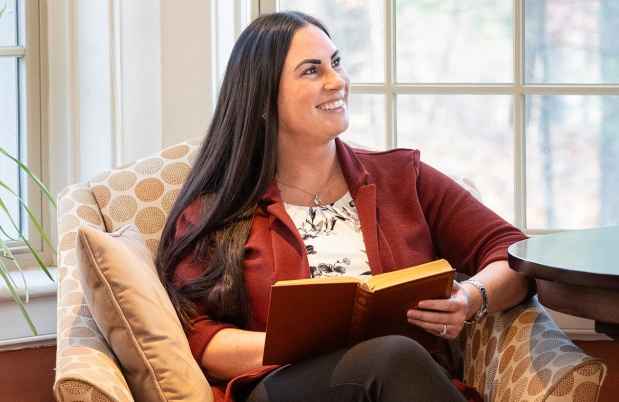 Person reads book in comfy chair