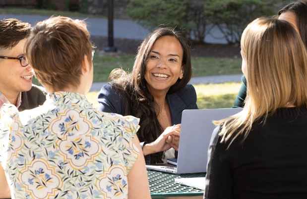Staff work together at an outdoor picnic bench