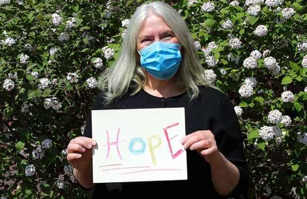Rebecca Sanford holds up handwritten sign Hope