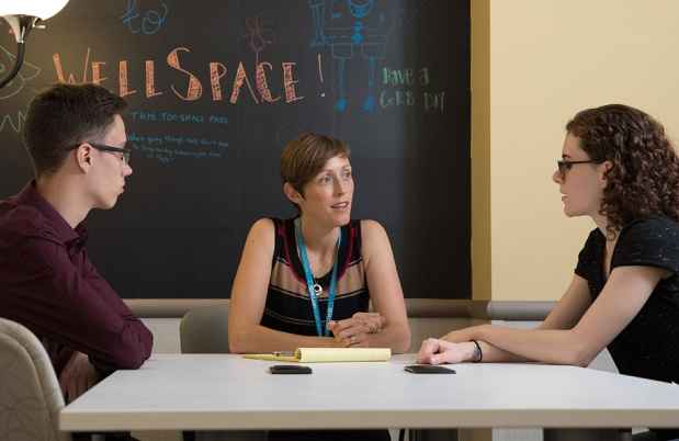 Clinician speaks with young adult patients in WellSpace