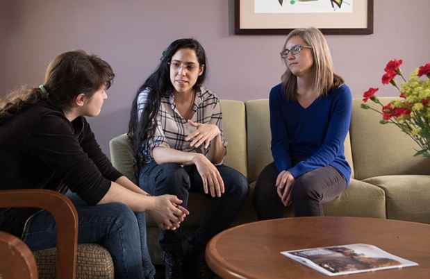 Young women talk sitting on couches