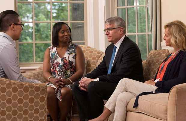 Patient and clinicians talk in living room