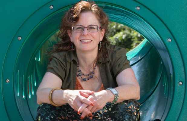 Nurse sits in green playground tube
