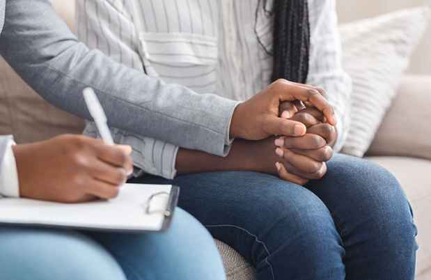Stock image of therapist’s hands holding that of a patient