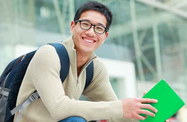 Stock photo of young man holding green notebook