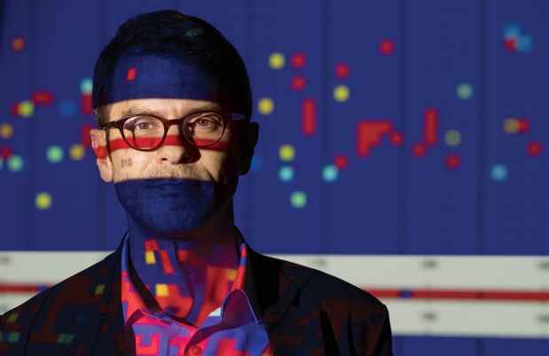 Justin T. Baker, MD, PhD, with graphs projected on and around him