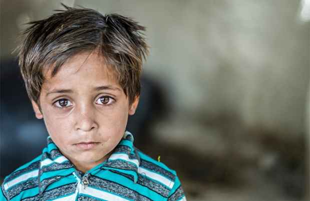 Young boy in green and white striped shirt.