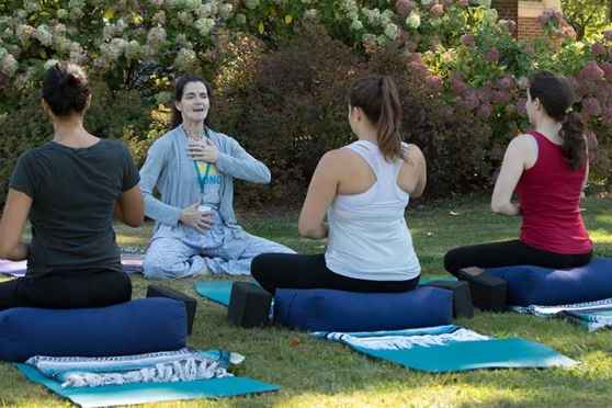 Group sitting on blankets outside with an instructor facing towards them