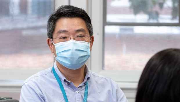 Clinician in mask talks to patient