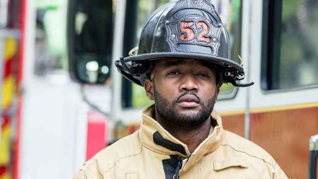Firefighter in gear by trucks