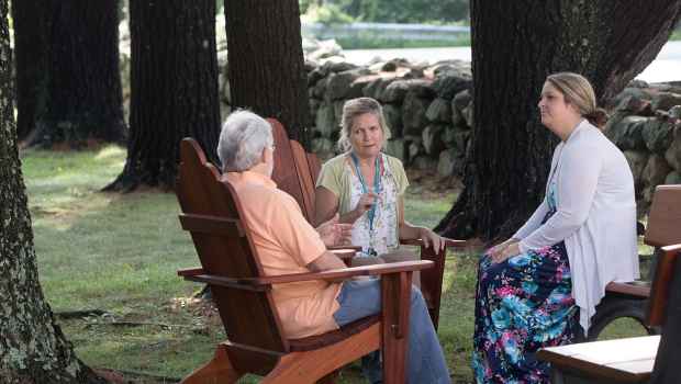 Clinician talks to patients in wooded area