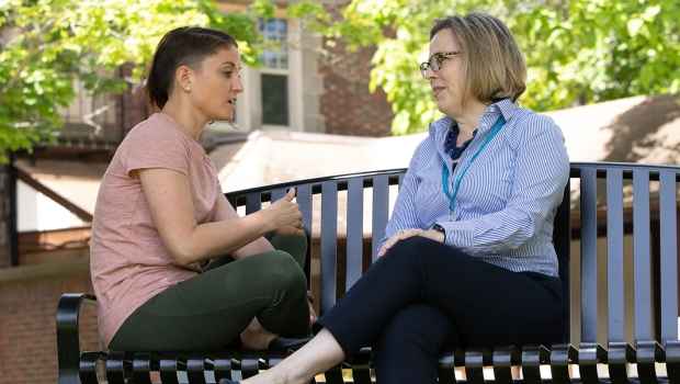 Girl and counselor talking on a park bench