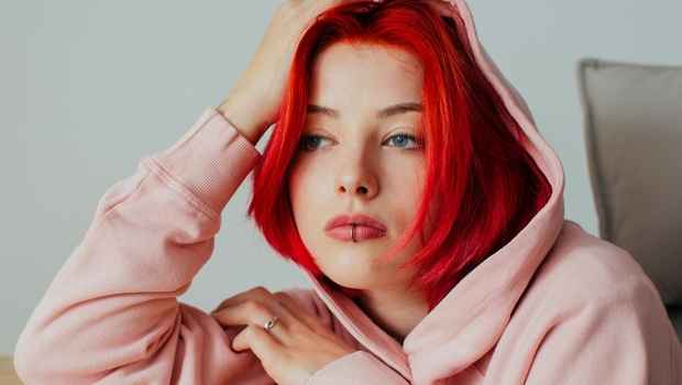 Teen girl with red hair stares off