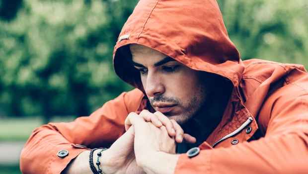 man in jacket looking sad and looking downwards