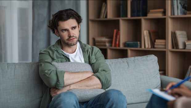 man sitting on couch in therapy