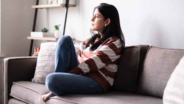 Woman sits on couch
