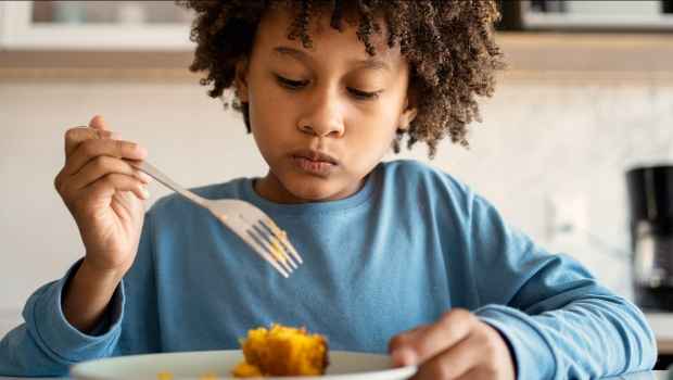 Child eating and looking down at their plate
