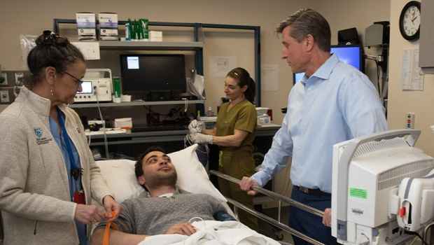 Doctor talks with patient in room with medical equipment
