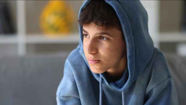 Stock image of teen in blue hoodie looking out