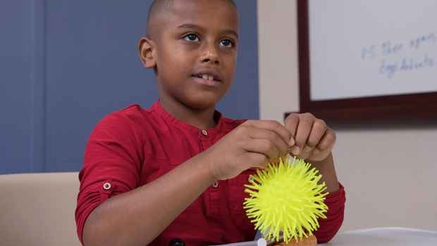Young boy plays with fidget ball